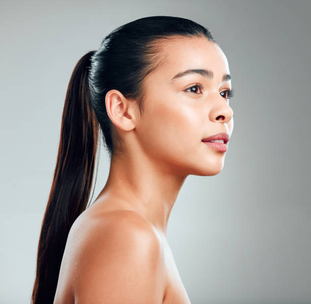 tiro de estúdio de uma bela jovem mulher posando contra um fundo cinza - cabelo preso - fotografias e filmes do acervo