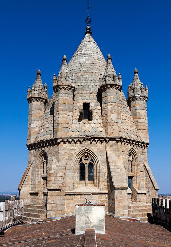 A tower of the cathedral in Evora, Portugal with a beautiful clear blue sky as a background.