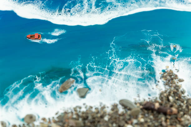 Resin art background. Epoxy art composition with ocean waves, boat and stone beach.
