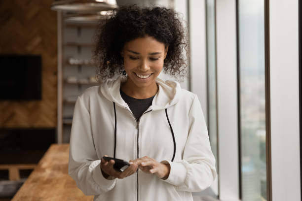 istock Smiling young African American woman using cellphone. 1387743648
