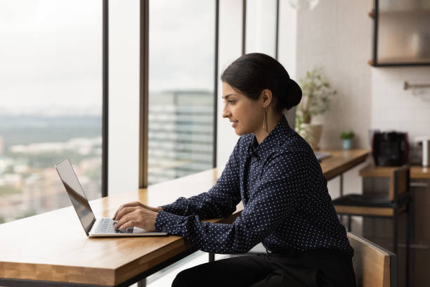 istock Happy young female Indian employee working on computer. 1387743679