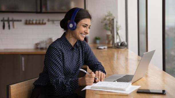 istock Happy millennial Indian woman e-learning at home. 1387743682