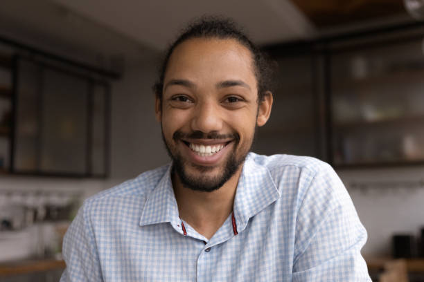 istock Smiling young African American man holding video call. 1387743693