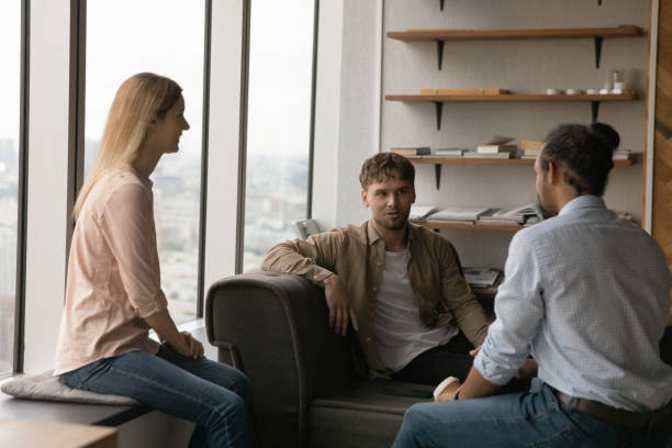 istock Happy young colleagues talking in office. 1387743701