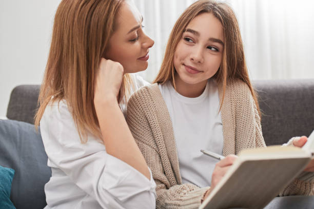 istock Mother helping daughter in doing homework 1387745887