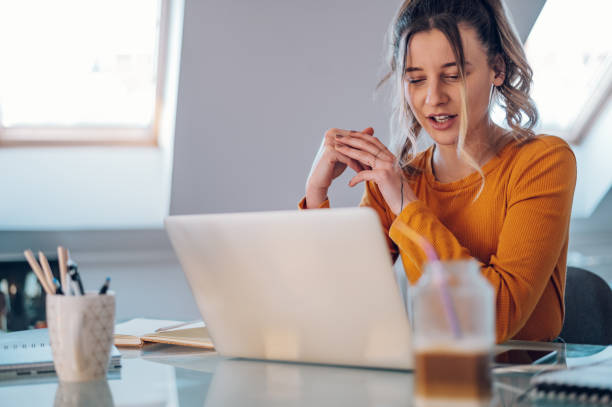 istock Woman having web call on a laptop while working at home 1387746218