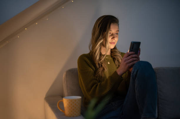 istock Woman using smartphone while sitting on the sofa at home 1387746228