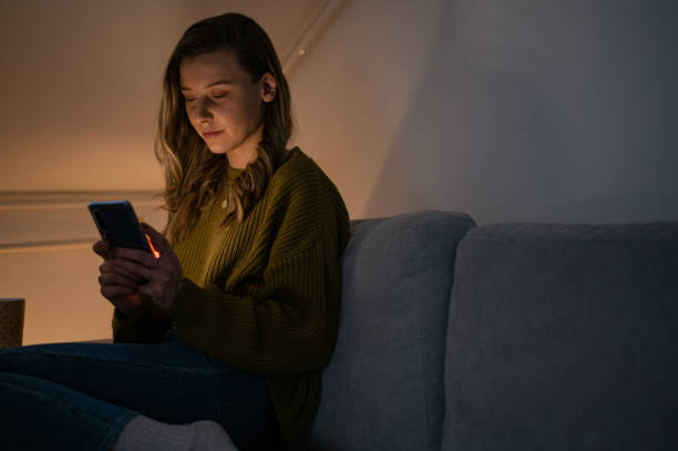istock Woman using smartphone while sitting on the sofa at home 1387746232