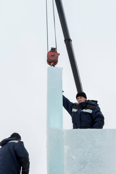 istock Workers assemble ice blocks on the frame of a wooden slide 1387746323