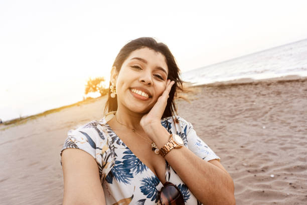 istock young woman taking a selfie winking. 1387748209