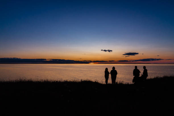 Silhouette of a girl in a dress in a yoga pose on the background of a beautiful orange sunset on the shore of Lake Zyuratkul, Chelyabinsk region, Russia