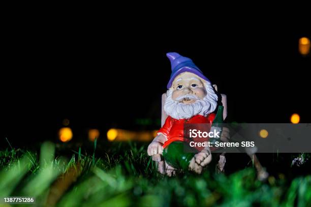 Relaxed Gnome Sitting On Lawn In The Middle Of The Night Stock Photo - Download Image Now