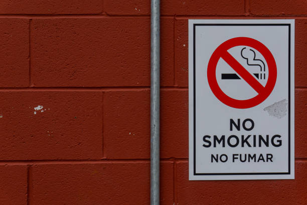 istock White No Smoking Sign In Front of Red Brick Wall With No Fumar Written Under 1387751830