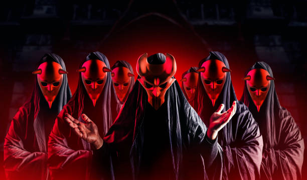 istock Occult horror sectarians with metal masks on black background. 1387752195