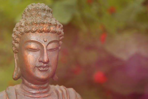 istock Buddha Statue in Garden with blurred flowers in background 1387756768