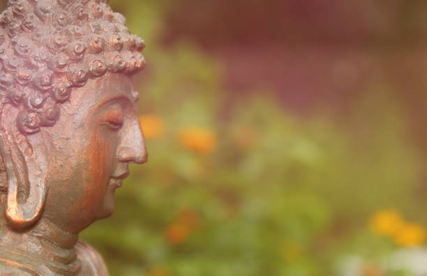 istock Buddha Statue in Garden with blurred flowers in background 1387756769