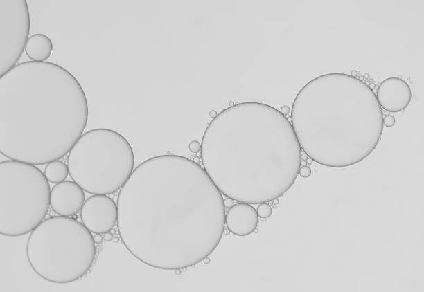 istock Oil droplets on water surface with silver-grey shadow background. 1387757849