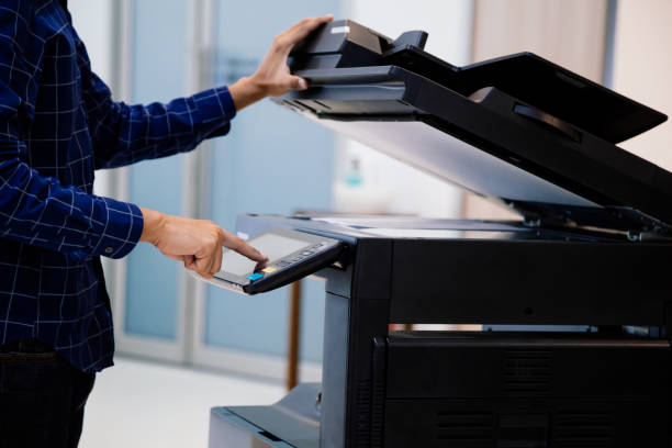 istock Businessmen press button on the panel for using photocopier or printer for printout and scanning document paper at office. 1387759709
