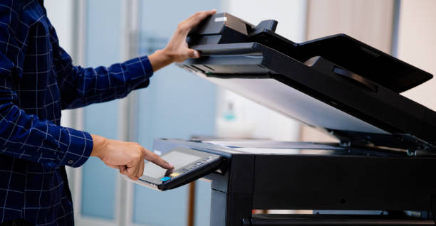 istock Businessmen press button on the panel for using photocopier or printer for printout and scanning document paper at office. 1387759714