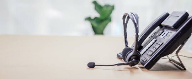istock Communication support, call center and customer service help desk. telephone devices with VOIP headset in office.Customer service support (call center) concept. 1387759720