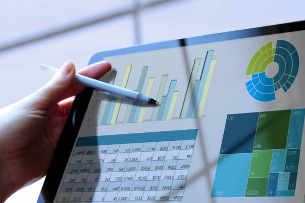 istock Business woman working and analyzing financial figures on a graphs on a tablet 1387763423