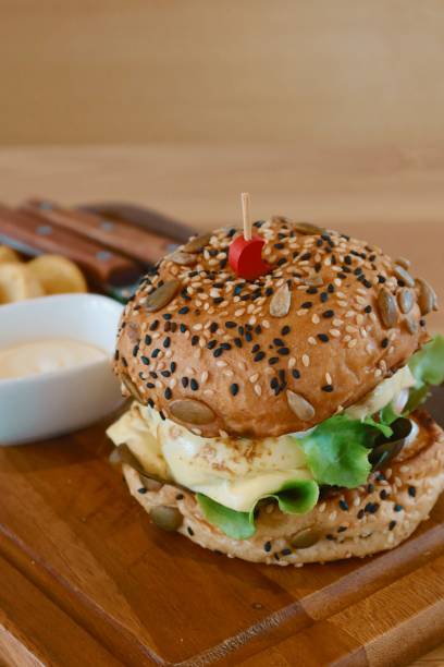 istock Closeup double cheese beef burger on wood plate 1387764236