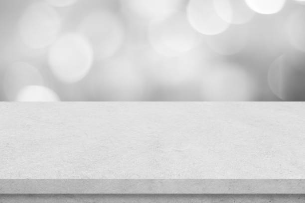 istock Empty white cement table over blur store background, product display montage, black and white tone, monochrome 1387764275