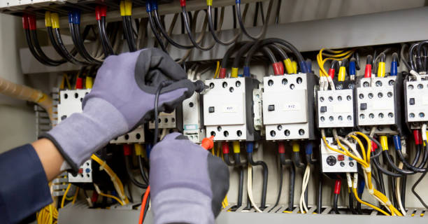 istock Electrician engineer tests electrical installations and wires on relay protection system. Adjustment of scheme of automation and control of electrical equipment. 1387764502