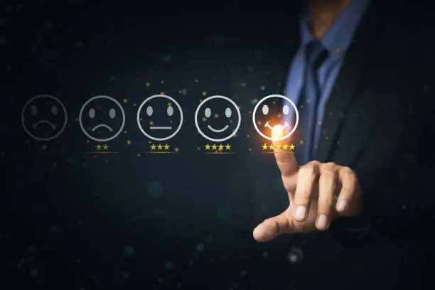 Photo of Customer Service and Satisfaction Concept Businessmen touch the virtual screen on happy smiley icons to achieve service satisfaction and feedback with excellent rated reviews.