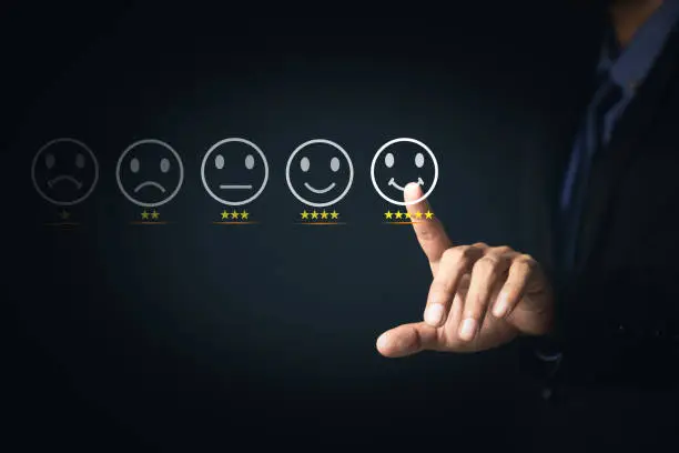 Photo of Customer Service and Satisfaction Concept Businessmen touch the virtual screen on happy smiley icons to achieve service satisfaction and feedback with excellent rated reviews.