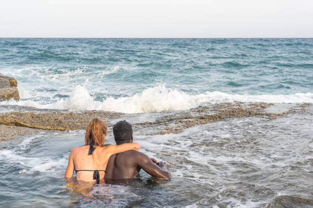 istock couple bathing in the sea embracing each other 1387767407
