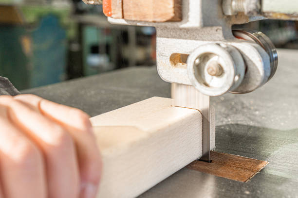 istock Unrecognizable carpenter cutting wood with band saw 1387770254
