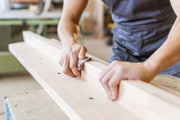 istock Crop artisan sanding wooden board in workshop 1387770288