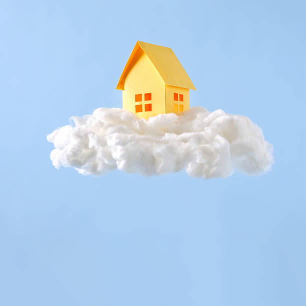 istock Yellow model house on a fluffy white cloud 1387772317