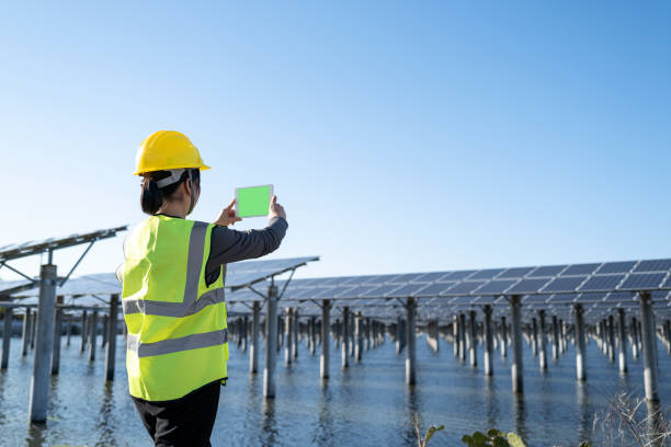 istock Female engineer at solar power plant using tablet to take photo 1387775252