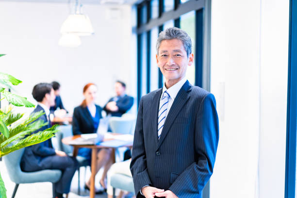 empresario anciano que trabaja con una sonrisa - director ejecutivo de empresa fotografías e imágenes de stock