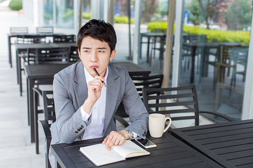 young handsome chinese businessman sitting in outdoor cafe to relax lifestyle