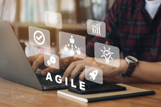 Person working on computer with icons of Agile development methodology concept on virtual screen. Technology concept. 