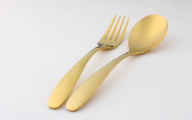 istock golden spoon and fork are placed on a white background. 1387779724