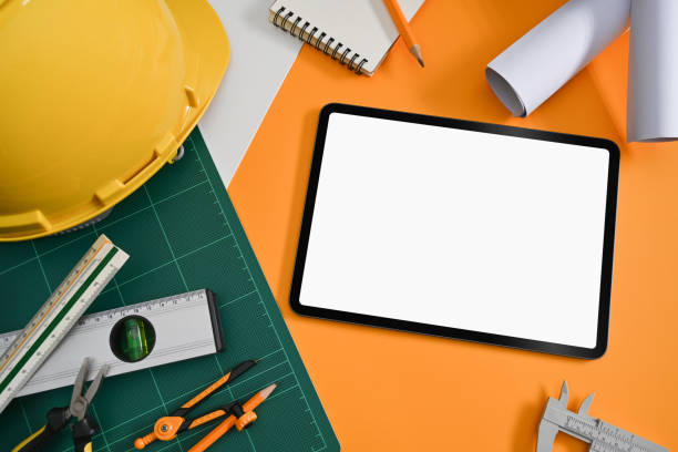 istock Mockup digital tablet, helmet, blueprints and mechanical tools on Architect workplace, Top view. 1387781955