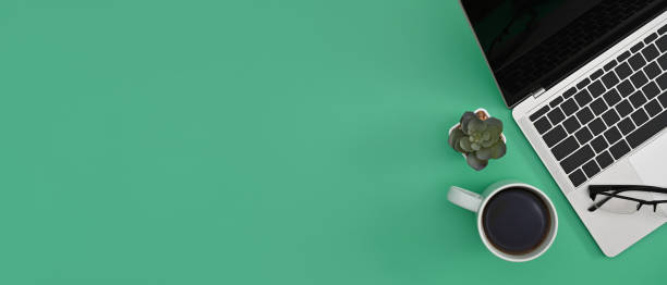 istock Computer laptop, coffee cup and succulent plant on green background with copy space for text. Flay lay. 1387782005