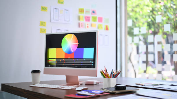 istock Modern computer pc with color chart on monitor screen, coffee cup and stationery at design studio. 1387782756