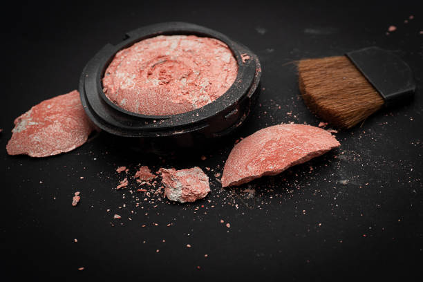 Blush on and brush is broken and scattered on a black background, Broken and cosmetic, cracked and disrupted. (Glitter Blush on)