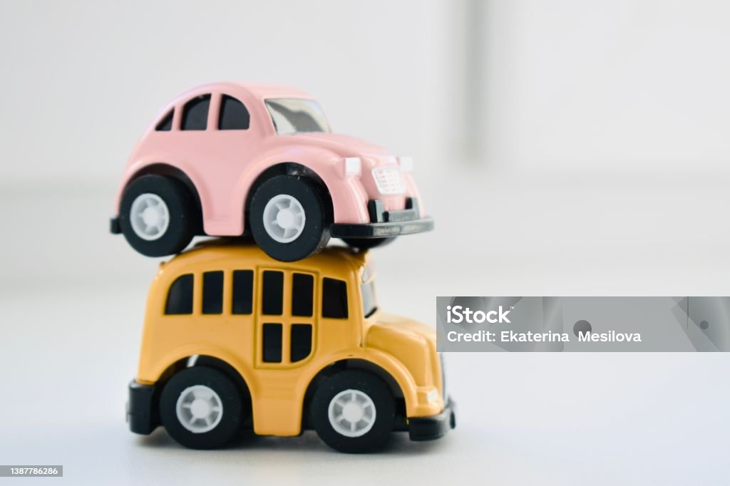 Pink and yellow toy cars on a white background, close-up with space for text Toy Car Stock Photo