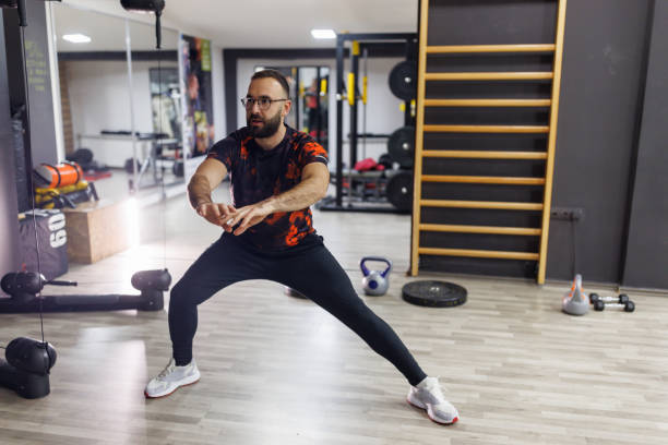 istock Young male athlete stretching before work out in the gym 1387787456