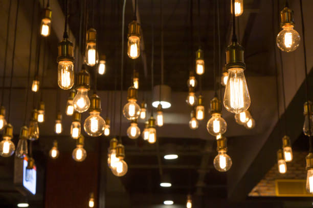 istock vintage light bulb hanging from ceiling for decoration in dark room. 1387790741