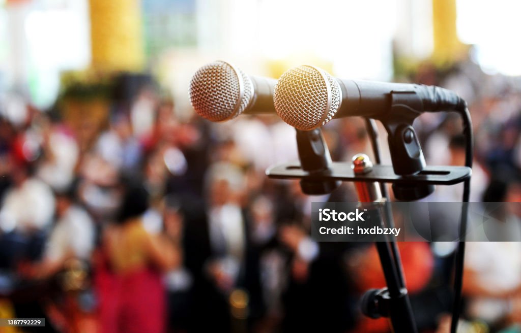microphone Closeup microphone in auditorium with people. Public Speaker Stock Photo
