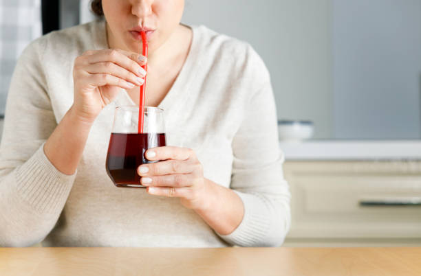 Close up of woman drinking pomegranate juice stock photo