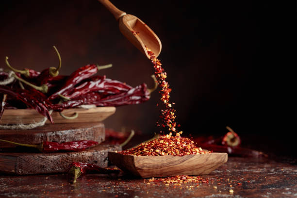 istock Chilli flakes are poured into a wooden dish. 1387796737