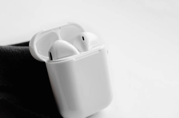 istock Wireless ear buds in glossy white plastic case on white background, close-up. Place for text, copyspace. 1387796890